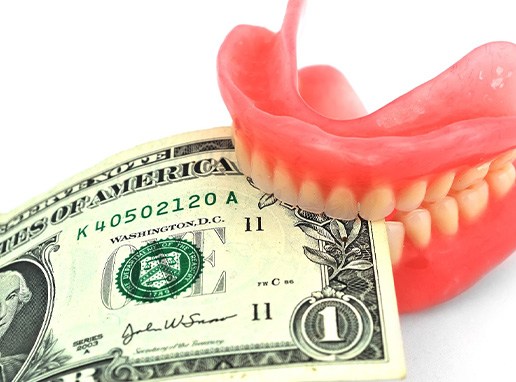 Dentures biting a dollar bill