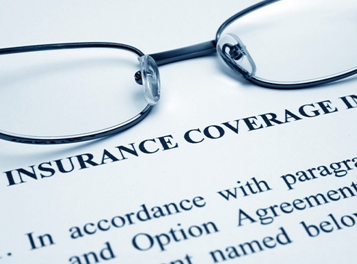 A dental insurance document and reading glasses