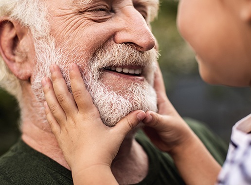 Older man sharing smile after denture tooth replacement