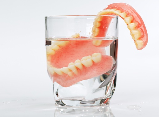 Set of dentures in glass of water