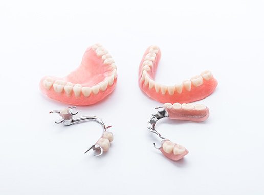 Full and partial dentures arranged in circle on white surface