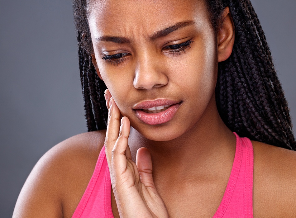 Woman in need of emergency dentistry holding jaw in pain