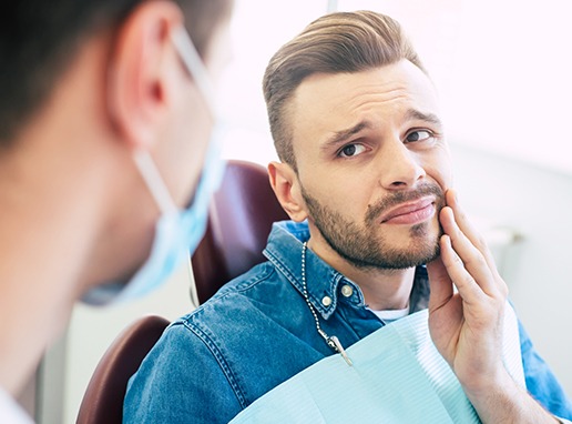 Man holding jaw before emergency dentistry