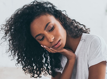 Woman with toothache holding jaw