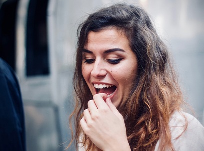 Woman removing dislodge dental crown from mouth