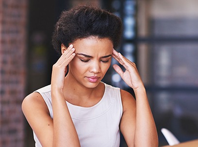 Woman with headache holding her temples