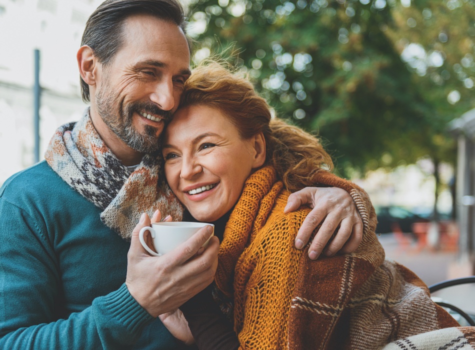 Man and woman smiling together after dental implant tooth replacement