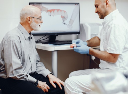 Dentist and dental patient reviewing the four step dental implant process