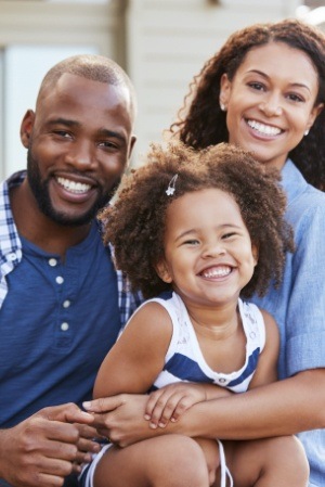 Mother father and child sharing healthy smile after receiving dental services