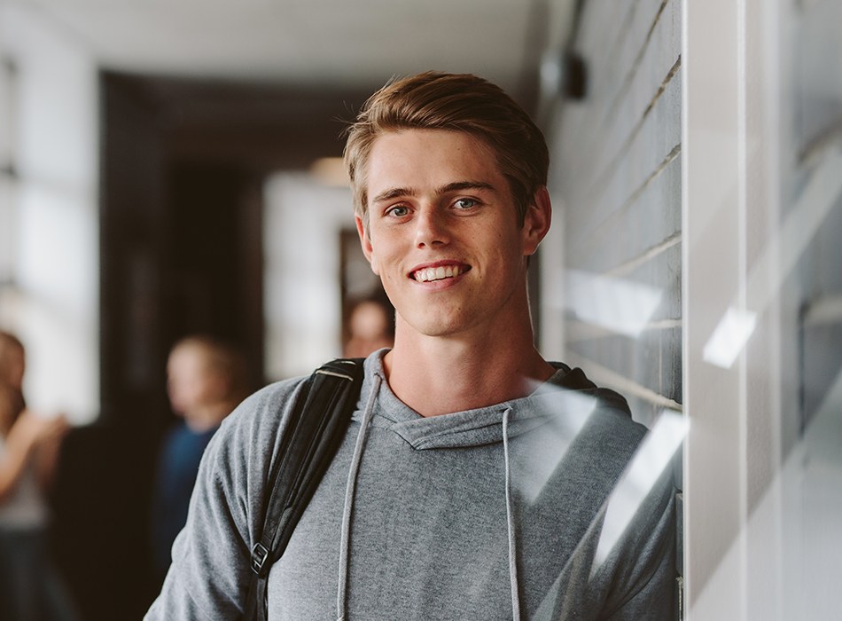 Young man with healthy smile after conservative inlay and onlay treatment