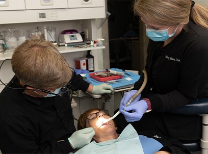 Dentist and team member treating dental patient