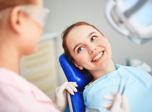 Woman smiling during dental checkup and teeth cleaning visit