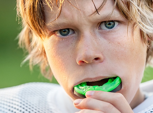 Teen boy placing athletic mouthguard