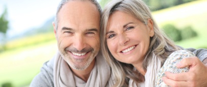 Man and woman smiling after replacing missing teeht