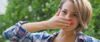 Woman in need of emergency dentistry covering her mouth