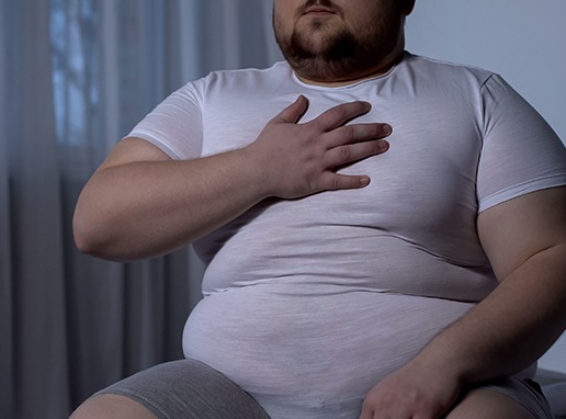Man in need of sleep apnea threatement holding chest