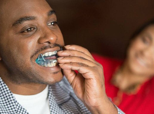 Man placing sleep apnea oral appliance