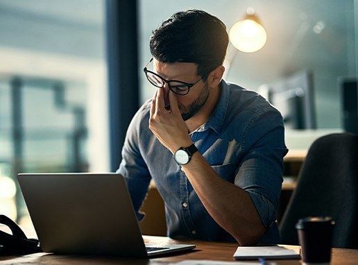 Man developing jaw pain holding his head