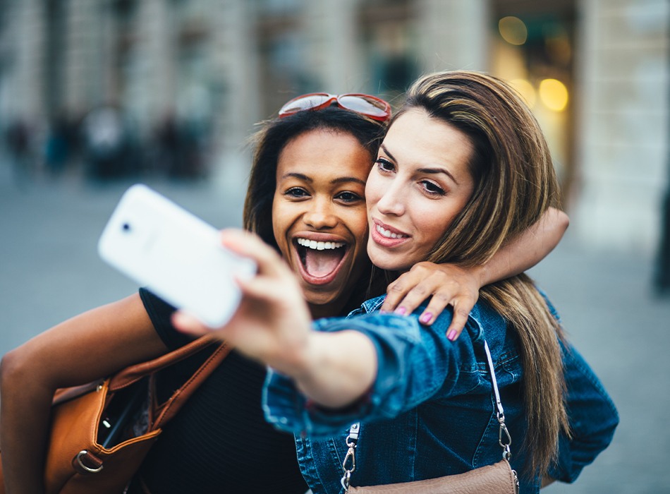 Two women with porcelain veneers taking a picture together