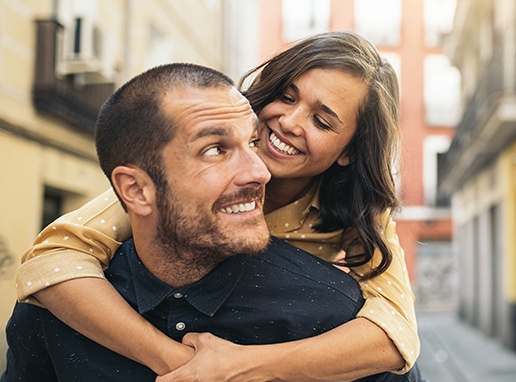 Man and woman smiling together after porcelain veneer placement