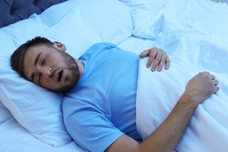 Man in blue shirt snoring due to sleep apnea