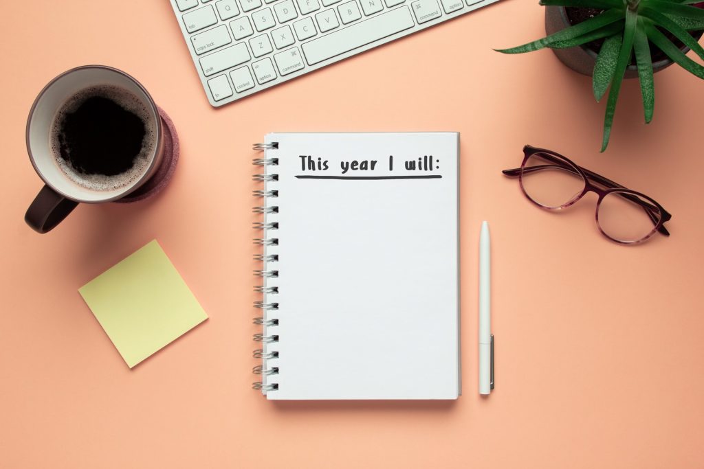 Pad of paper next to glasses, pen, and office supplies