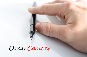Hand and pen over the words “Oral Cancer”