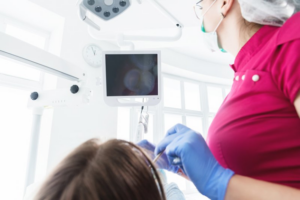 Dentist and patient using an intraoral camera and looking at the chairside monitor